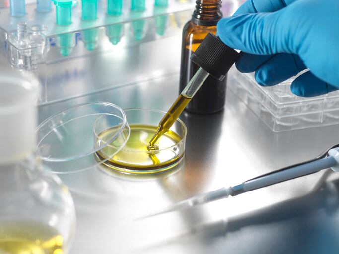 Scientist-holding-pipette-with-essential-oil-stock-photo.jpg