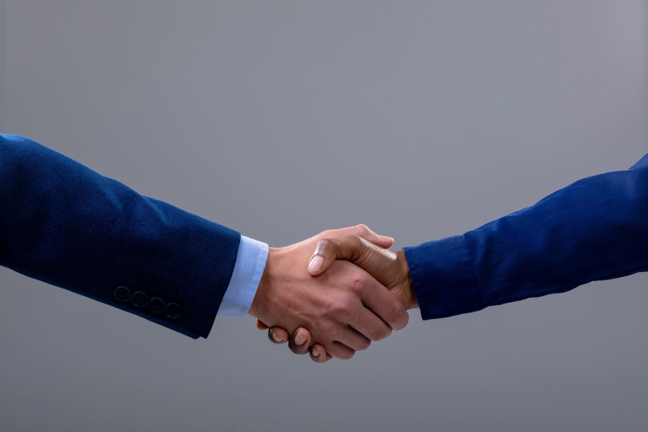 Caucasian and african american business people shaking hands, isolated on grey background. business technology, communication and growth concept.